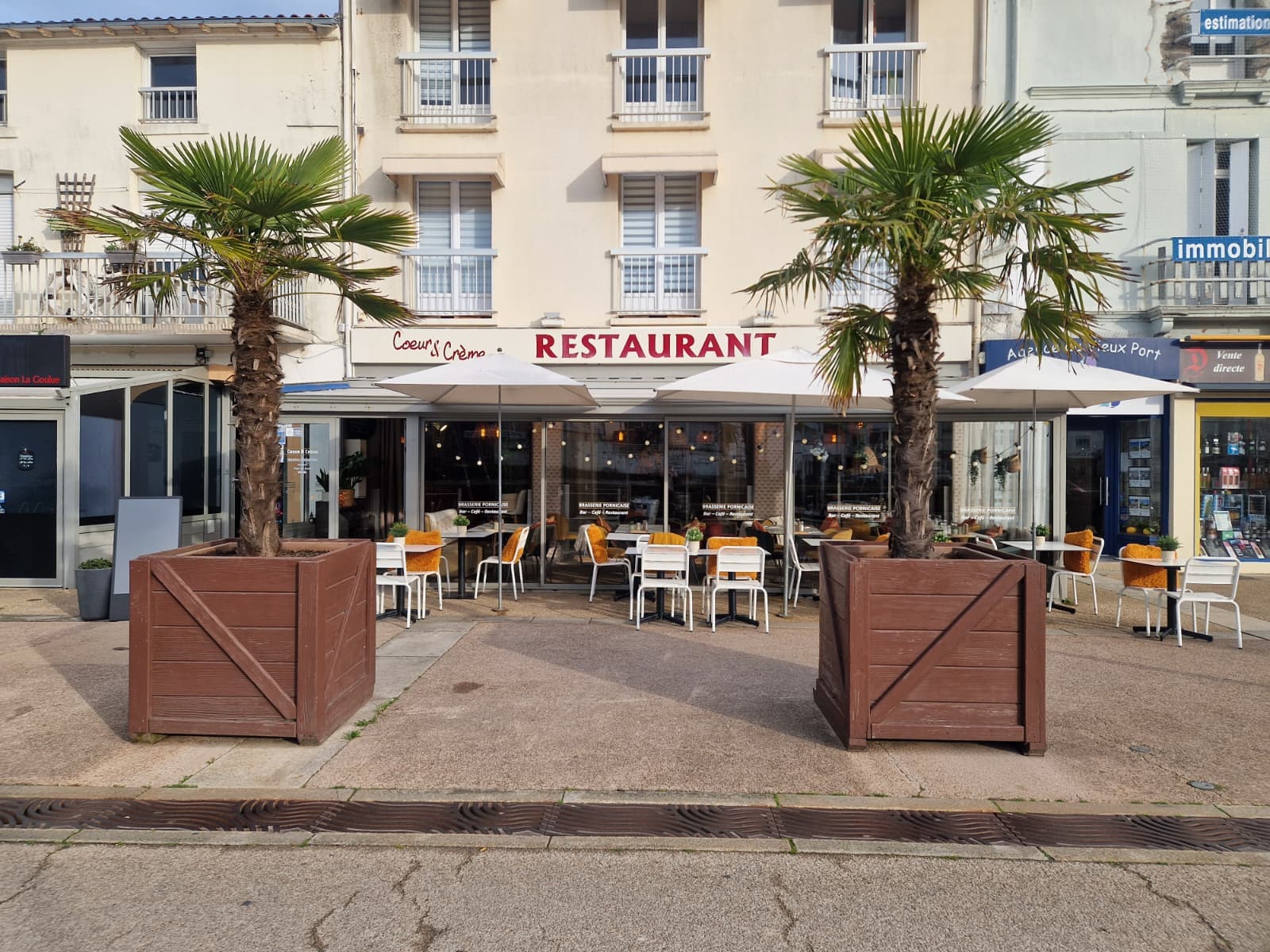 Facade du restaurant Coeur et Creme sur le quai Leray a Pornic avec terrasse et palmiers